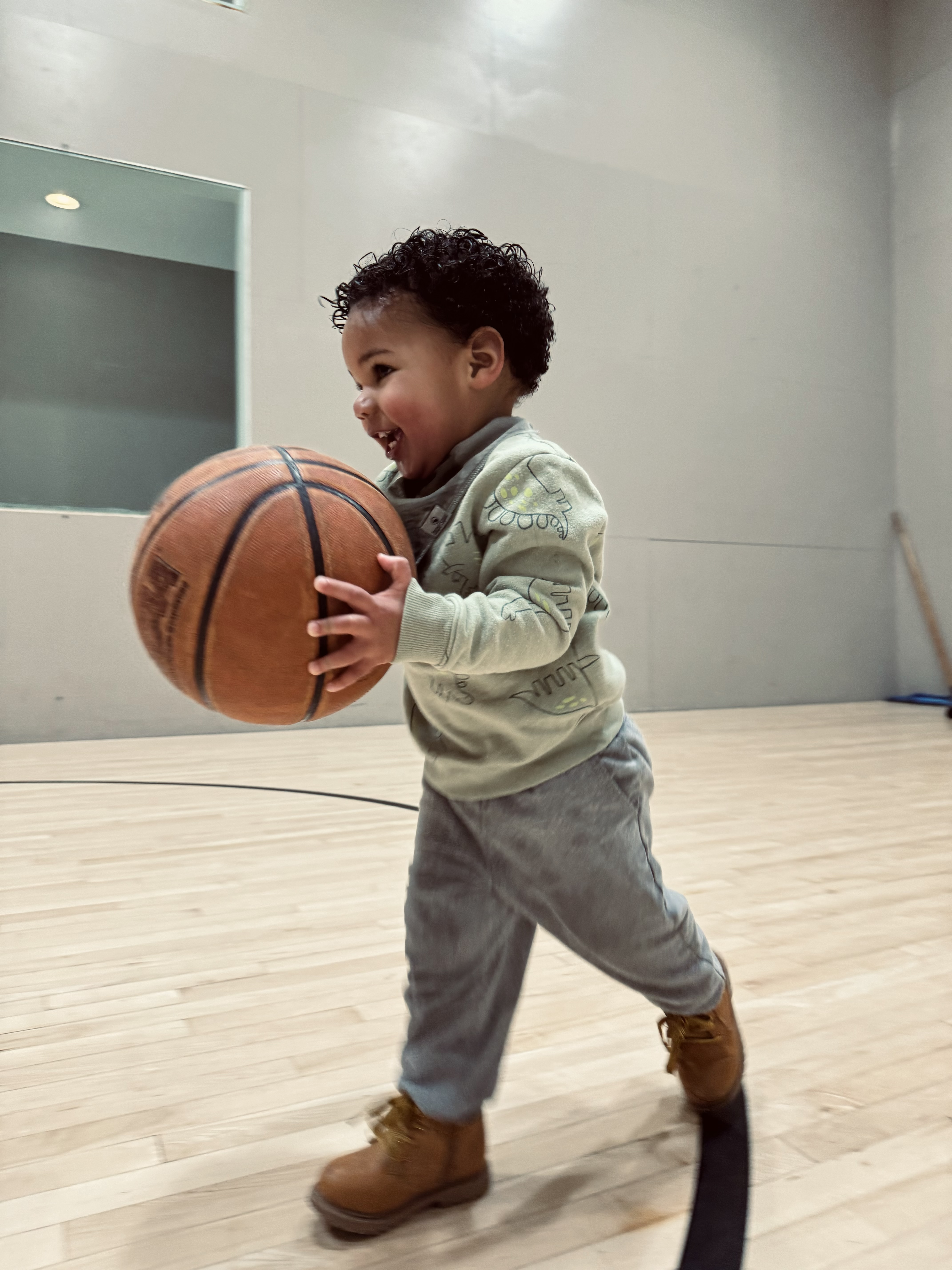 Coach Kaimyn's son running with a basketball on court